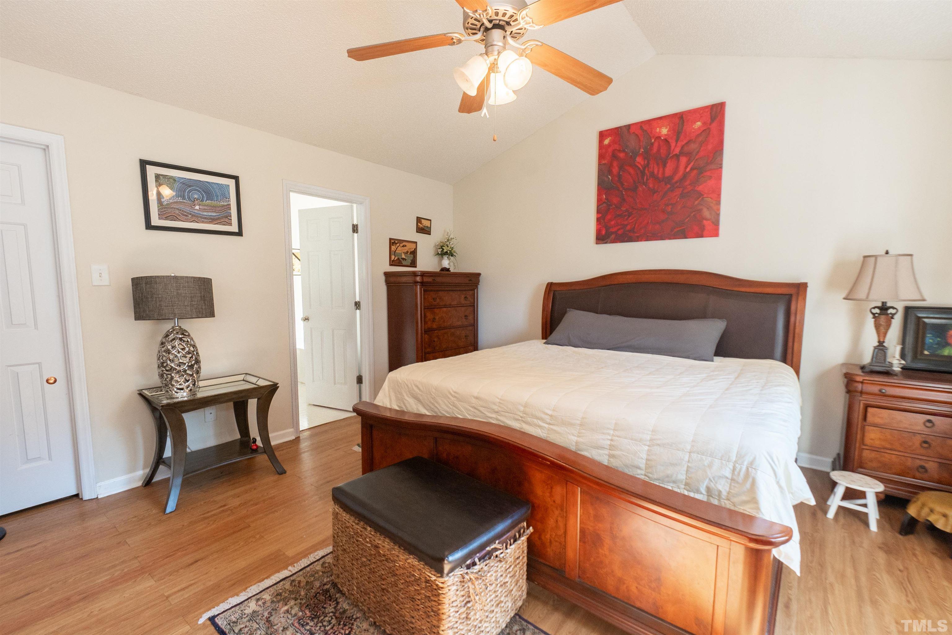 128 Edmondson Drive Willow Spring, NC 27592 - Photo 16 of 24 a bedroom with a bed and a chandelier