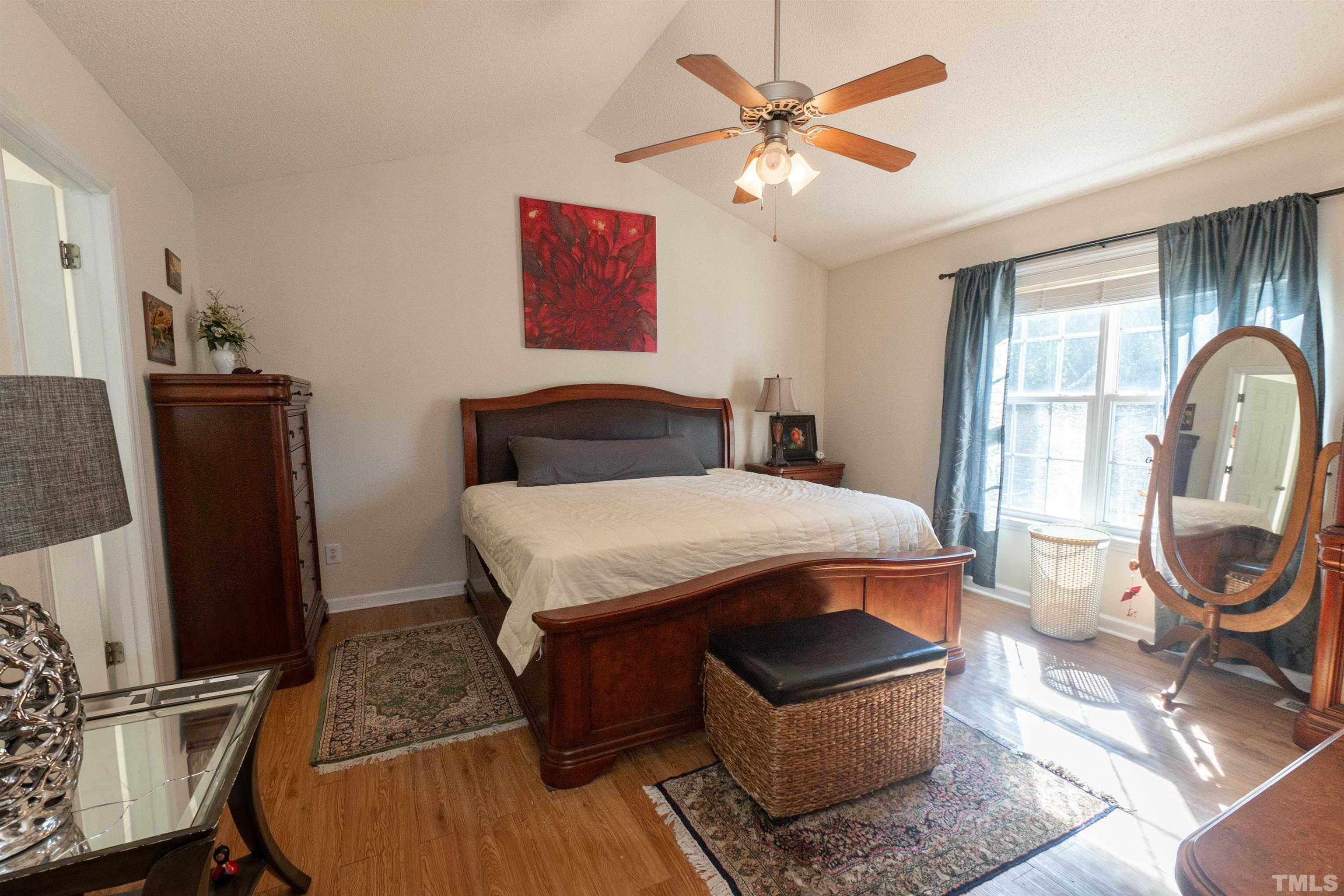 128 Edmondson Drive Willow Spring, NC 27592 - Photo 17 of 24 a bedroom with a bed a dresser and a chandelier