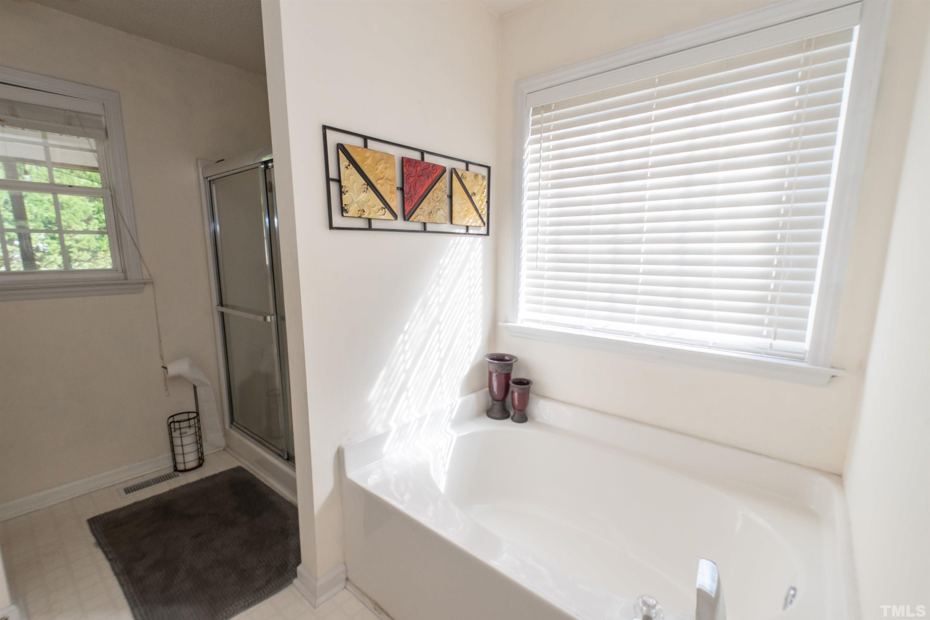 128 Edmondson Drive Willow Spring, NC 27592 - Photo 18 of 24 a bathroom with a bathtub and a window