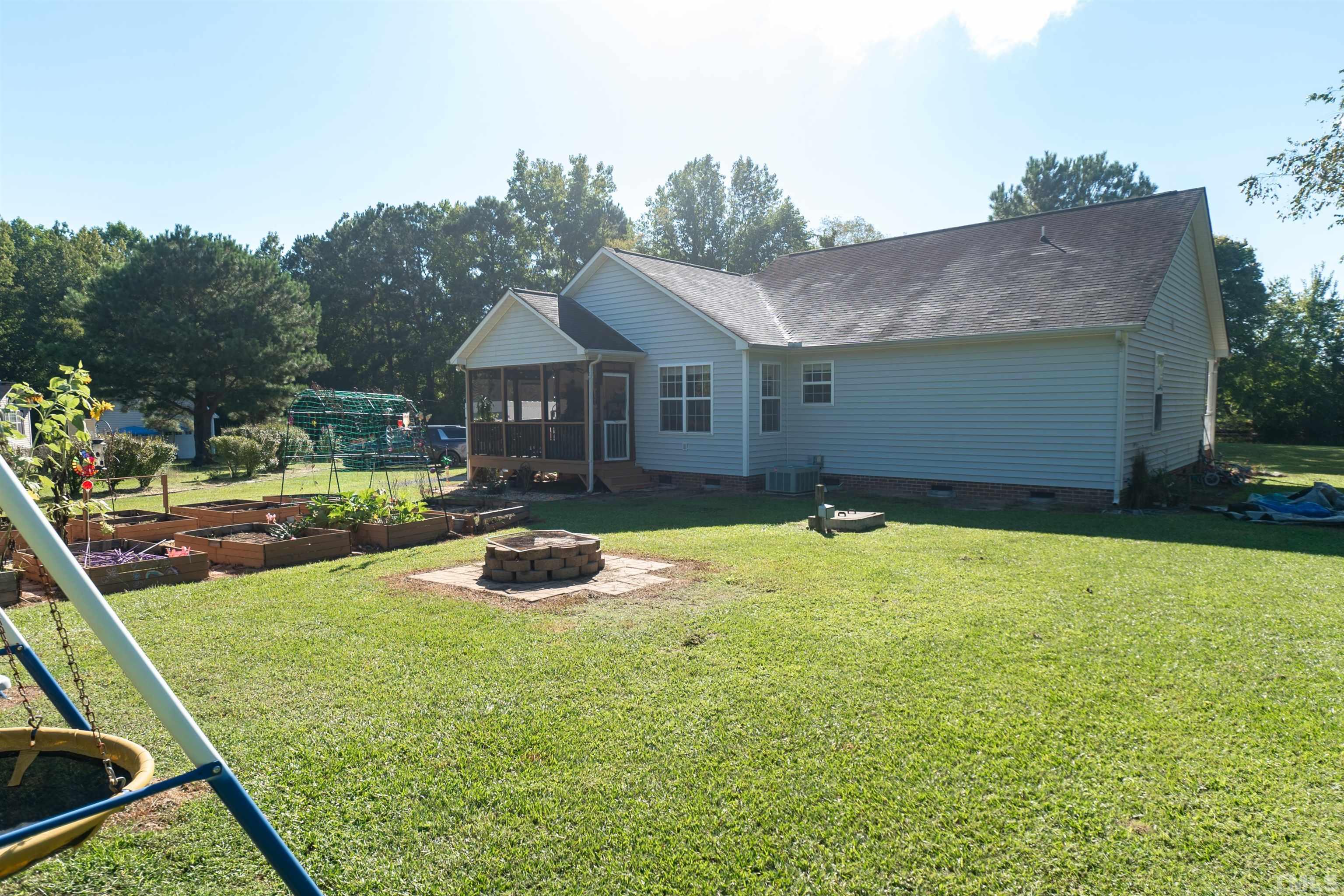 128 Edmondson Drive Willow Spring, NC 27592 - Photo 23 of 24 a front view of a house with a yard table and chairs