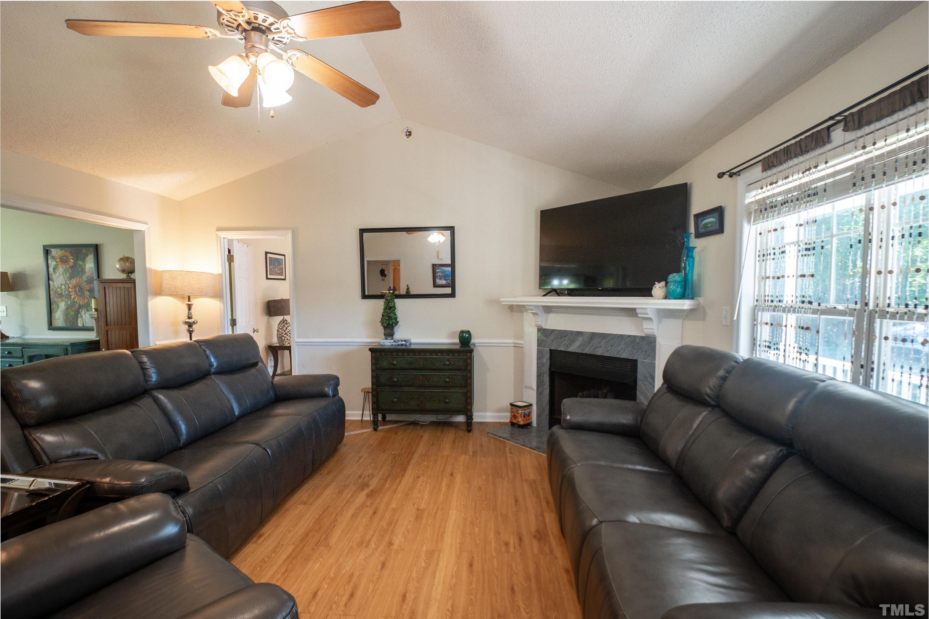 128 Edmondson Drive Willow Spring, NC 27592 - Photo 6 of 24 a living room with furniture a fireplace and a flat screen tv