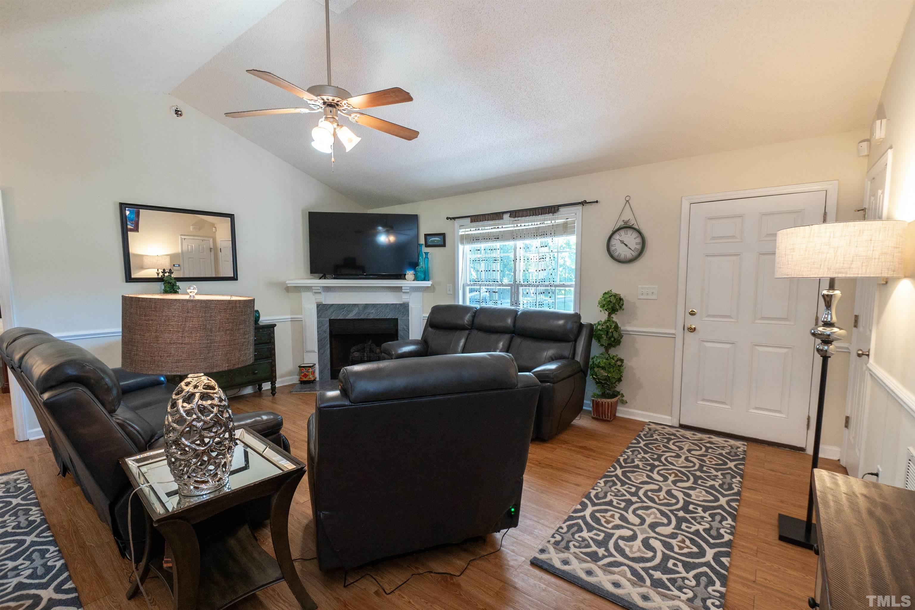 128 Edmondson Drive Willow Spring, NC 27592 - Photo 7 of 24 a living room with furniture a flat screen tv and a fireplace
