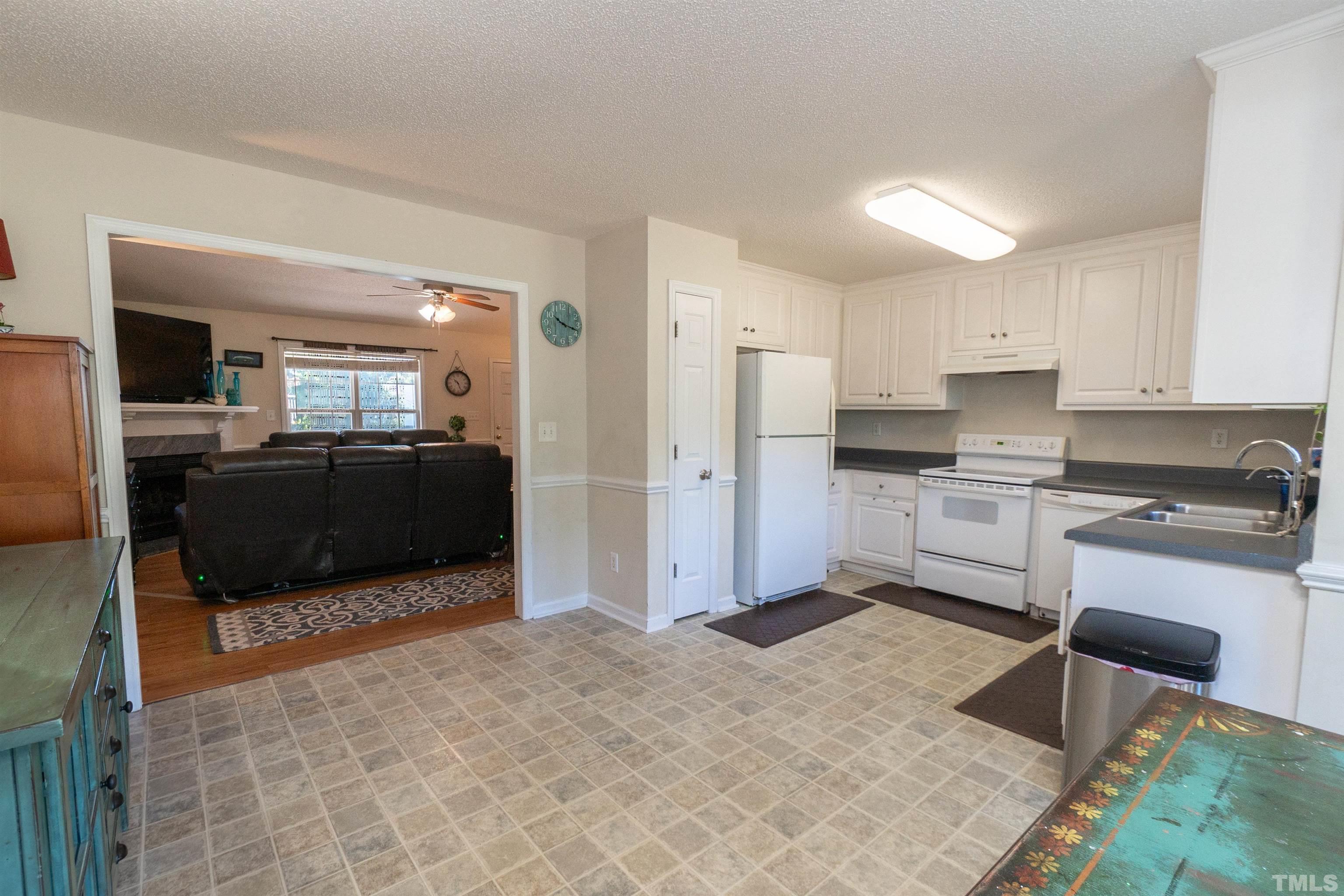 128 Edmondson Drive Willow Spring, NC 27592 - Photo 9 of 24 a kitchen with granite countertop a refrigerator and a stove top oven