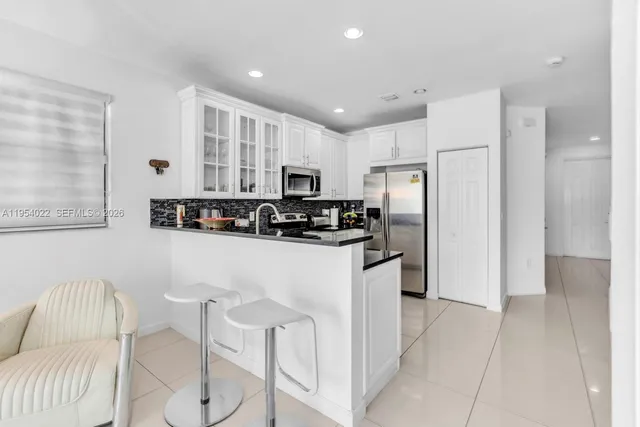 a kitchen with stainless steel appliances granite countertop a refrigerator and a stove top oven