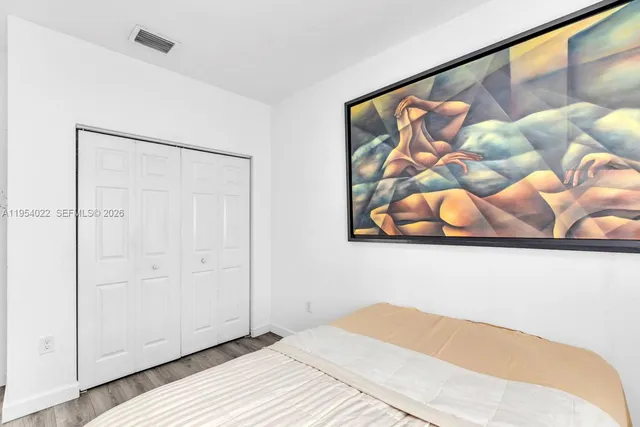 a bedroom with a bed and painting on the wall