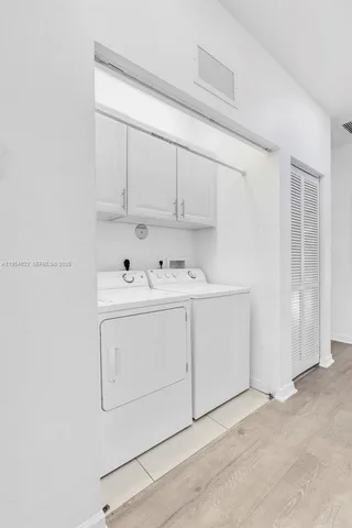 a utility room with cabinets washer and dryer