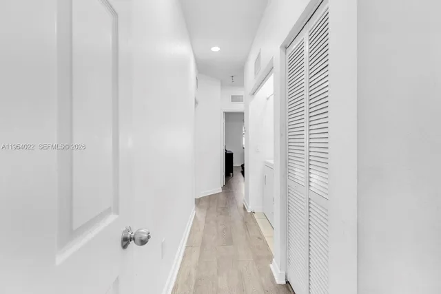 a view of a hallway with wooden floor