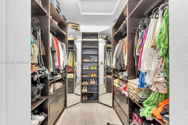 a view of walk in closet with clothes and shoes