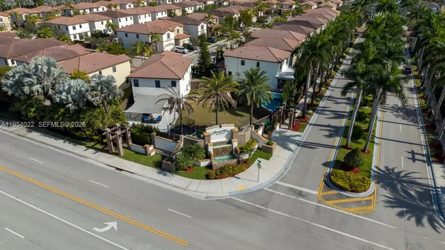 an aerial view of ocean and residential houses with outdoor space