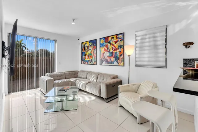 a living room with furniture and a wall painting