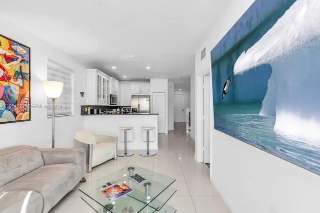 a living room with furniture and kitchen view