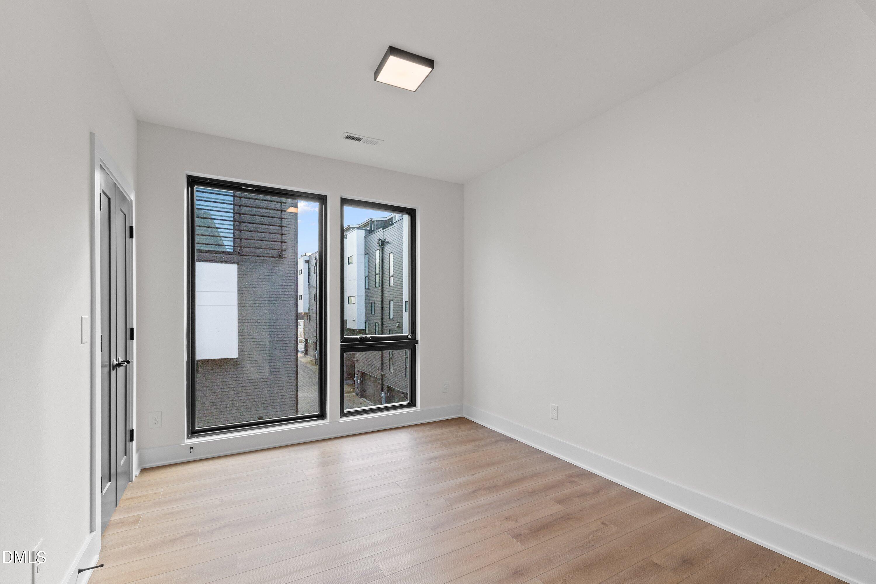 512 Gordon Street, Unit 901 Durham, NC 27701 - Photo 13 of 30 an empty room with wooden floor and windows