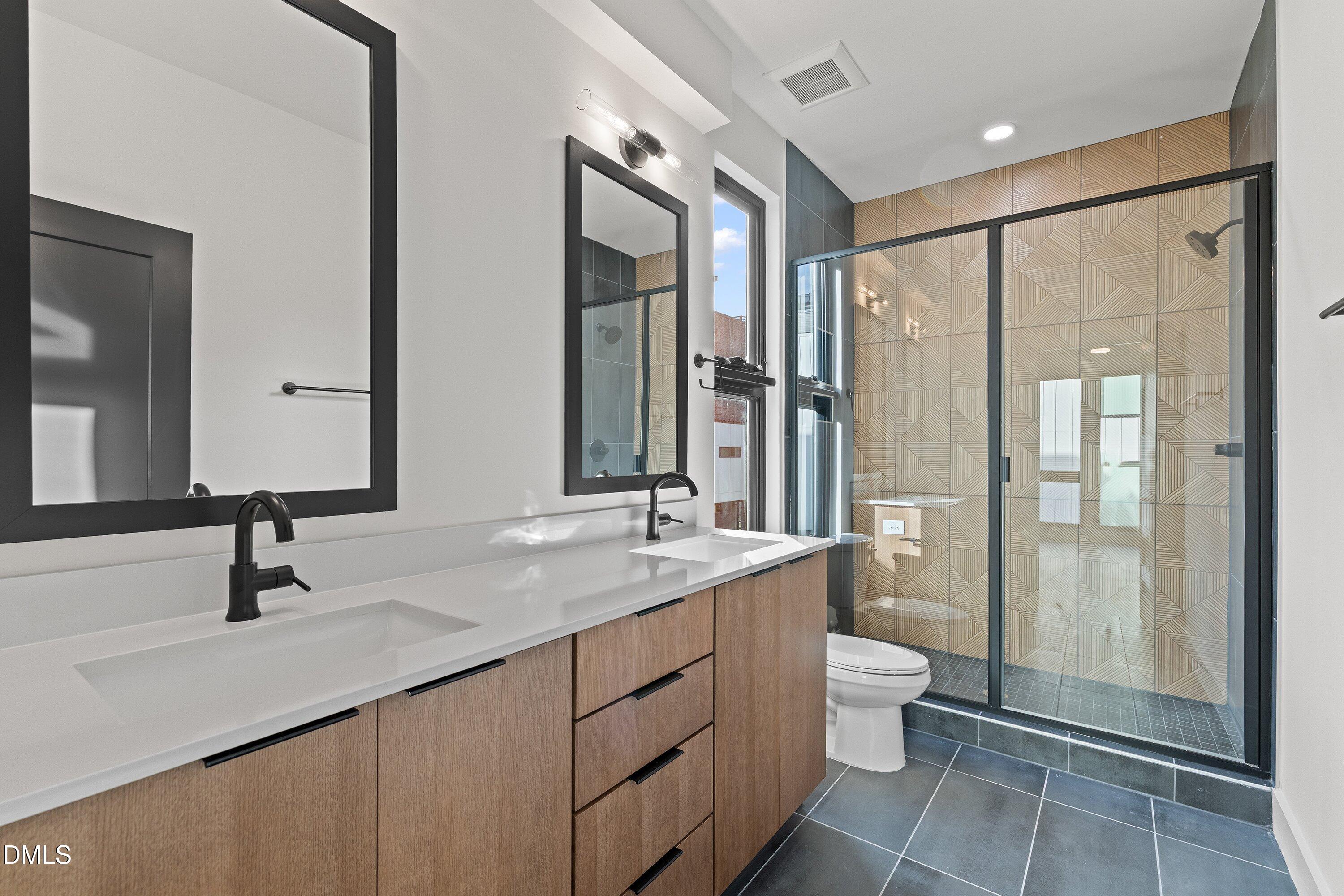 512 Gordon Street, Unit 901 Durham, NC 27701 - Photo 18 of 30 a bathroom with a double vanity sink toilet and shower