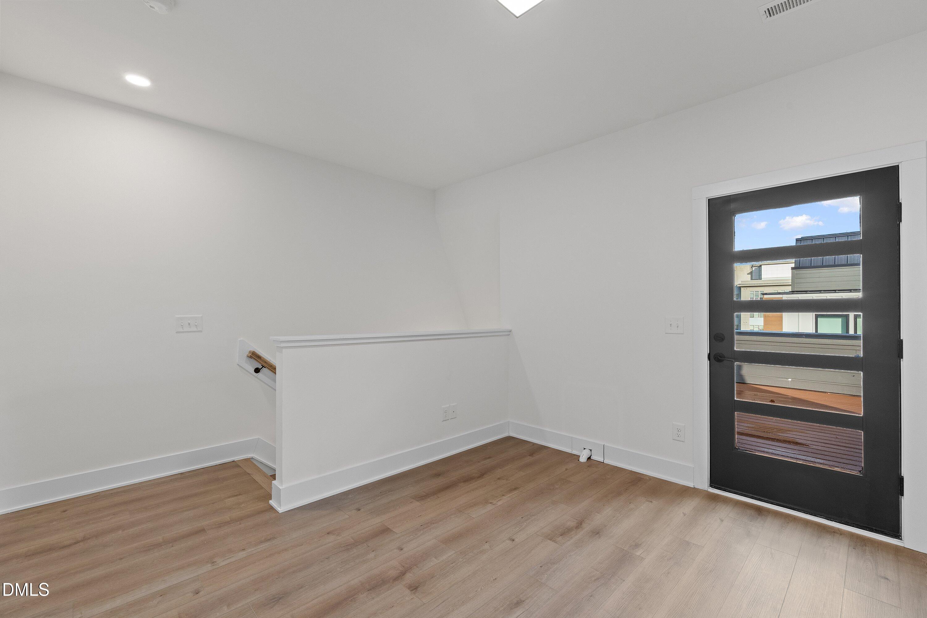 512 Gordon Street, Unit 901 Durham, NC 27701 - Photo 20 of 30 a view of an empty room with wooden floor and a window