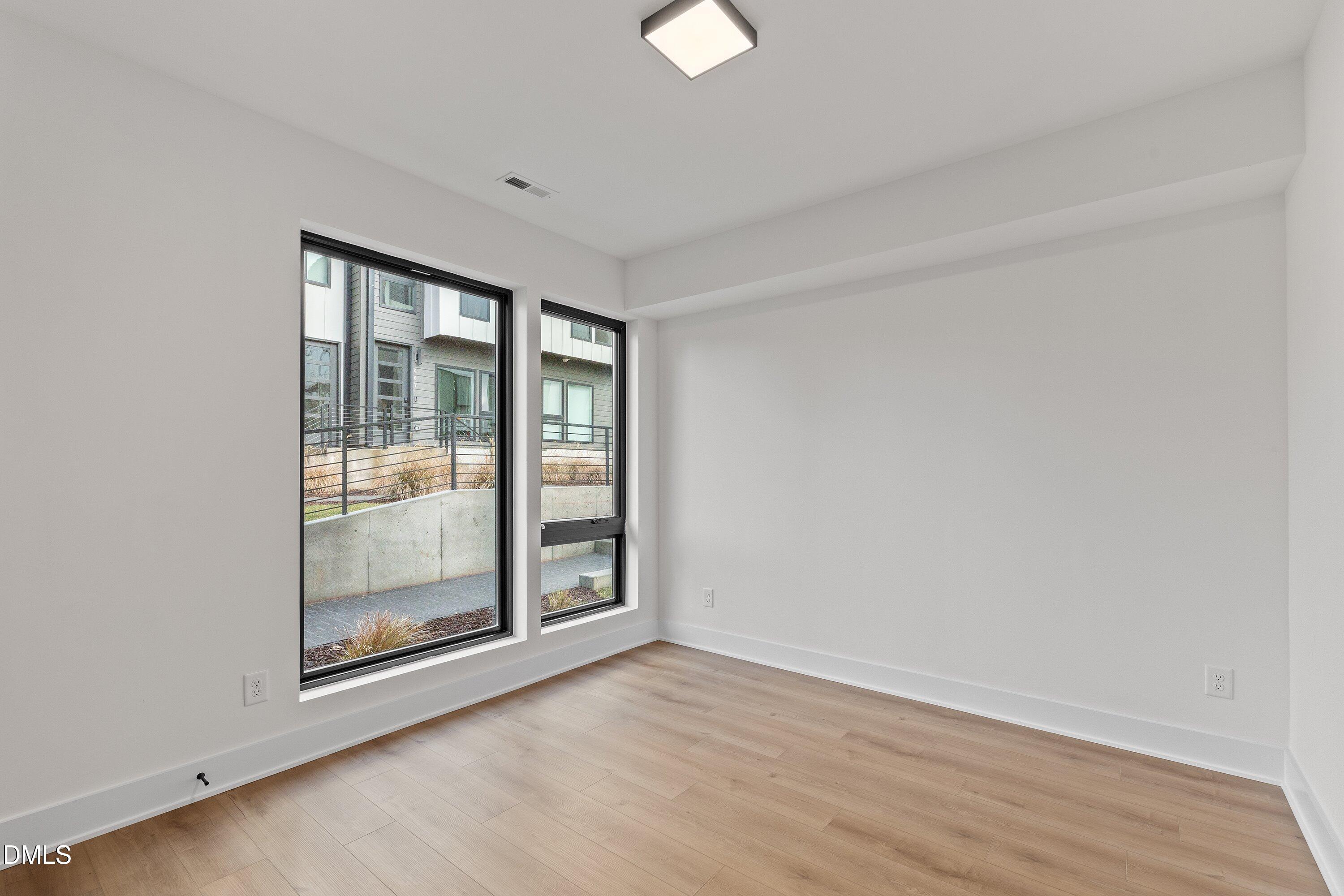 512 Gordon Street, Unit 901 Durham, NC 27701 - Photo 5 of 30 a view of an empty room with wooden floor and a window