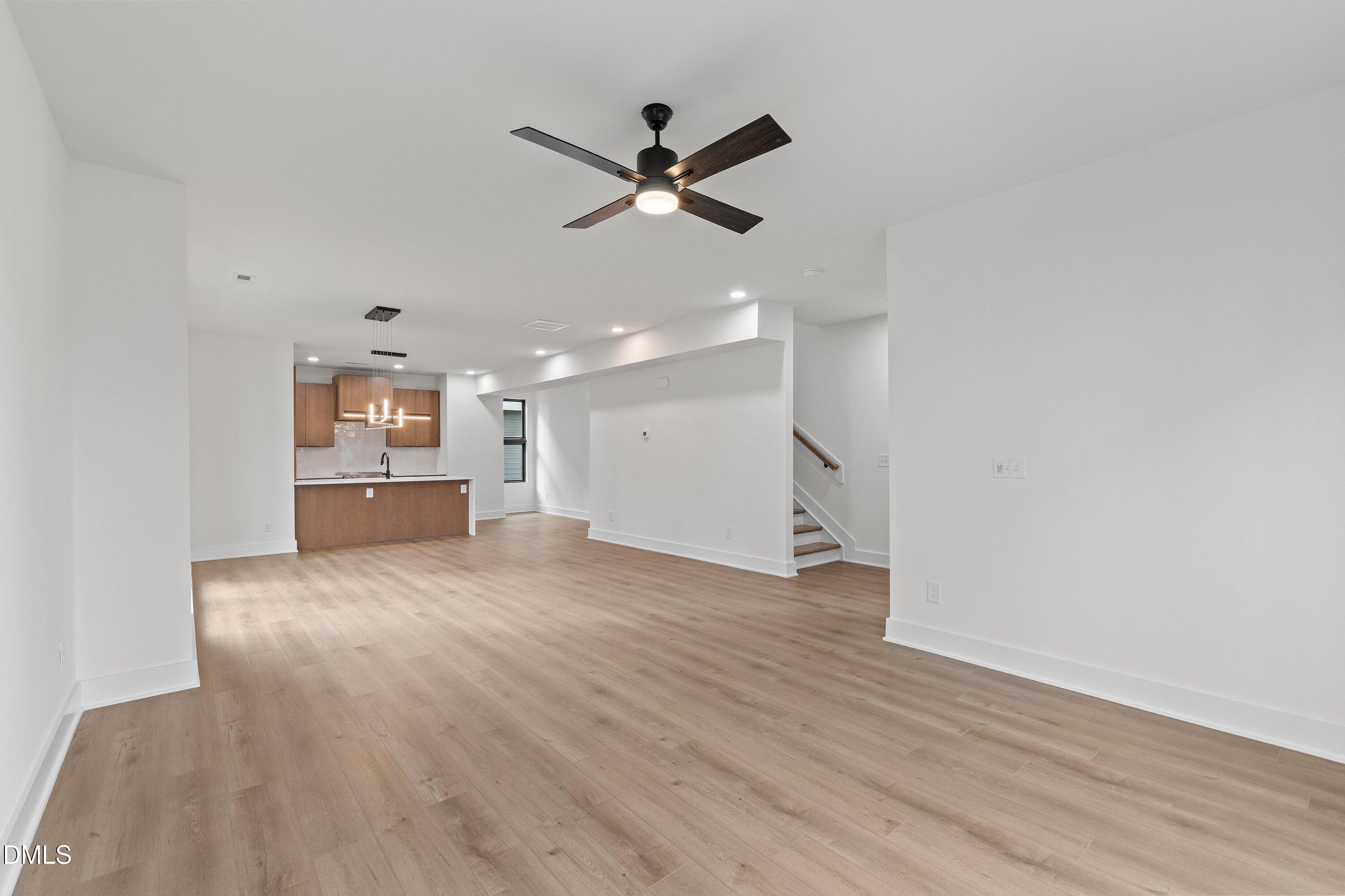 512 Gordon Street, Unit 901 Durham, NC 27701 - Photo 9 of 30 a view of an empty room with a ceiling fan and wooden floor