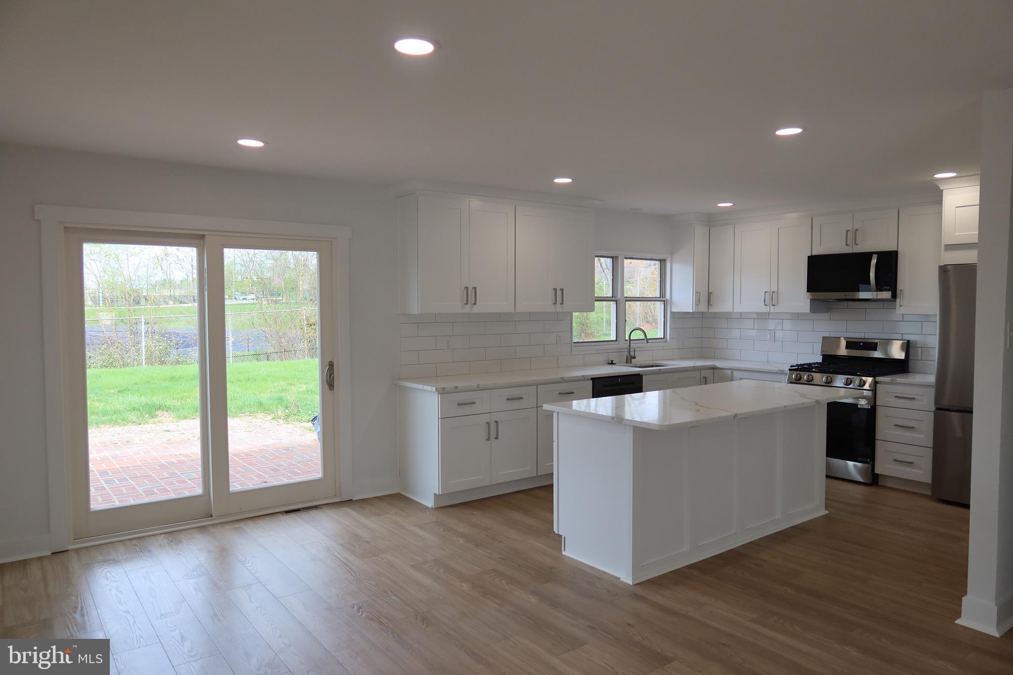 700 Fraser Road Glenside, PA 19038 - Photo 13 of 46 a kitchen with a stove a sink a microwave a window and a counter top space