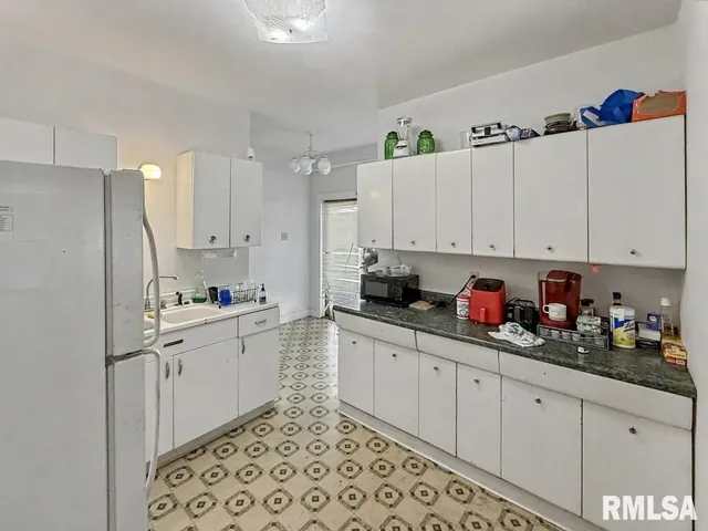 a kitchen with white cabinets and white appliances