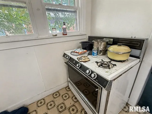 a stove top oven sitting inside of a kitchen
