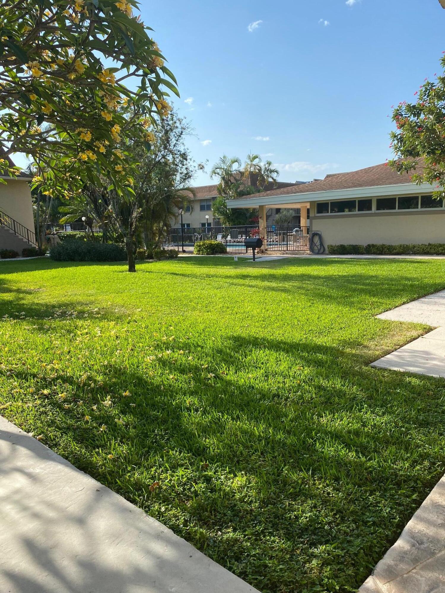 1271 Northwest 13th Street, Unit 361E Boca Raton, FL 33486 - Photo 17 of 19 a front view of house with yard and outdoor seating