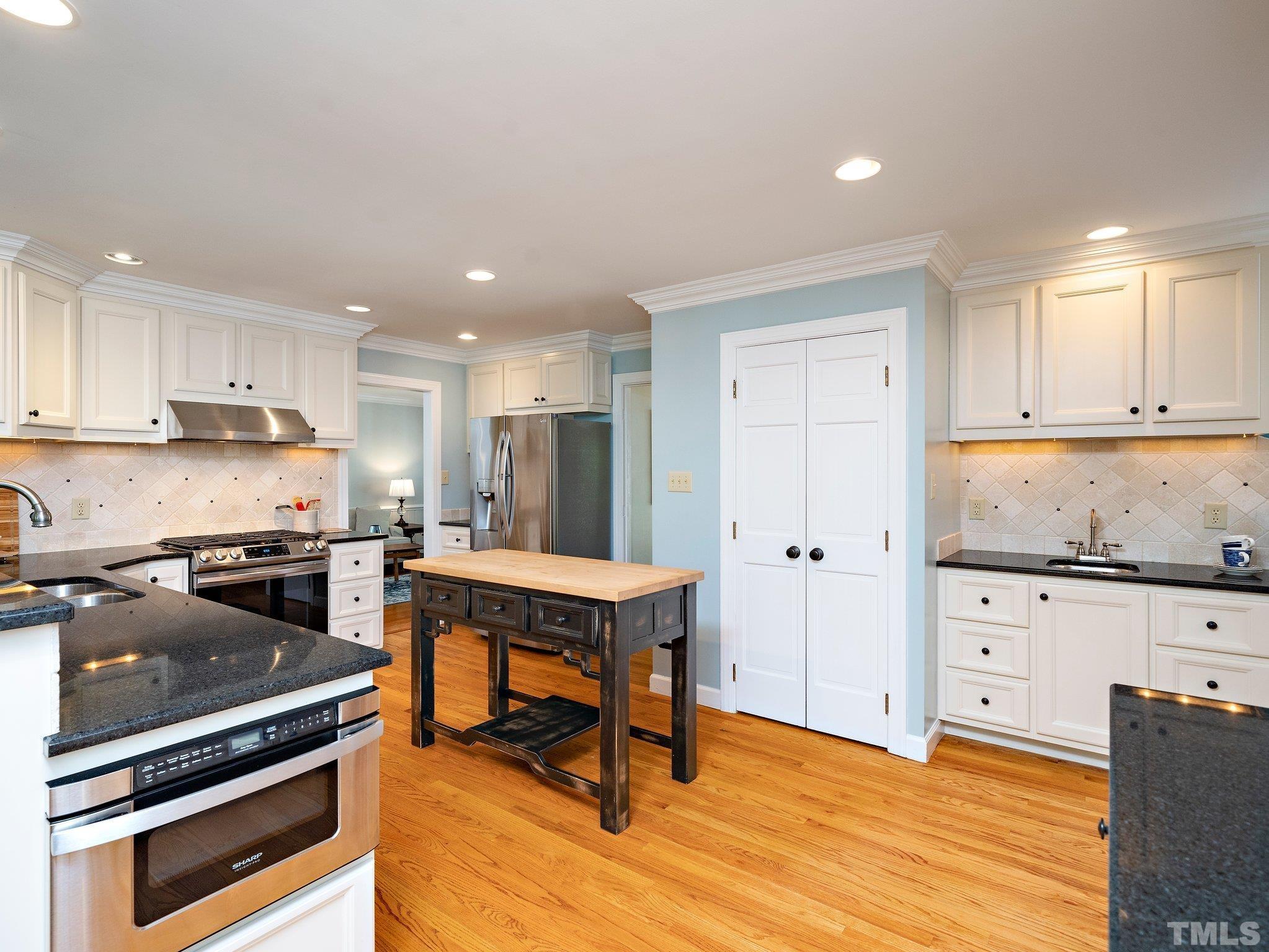 4508 Old Village Road Raleigh, NC 27612 - Photo 4 of 29 a kitchen with stainless steel appliances granite countertop a stove a refrigerator and a stove top oven