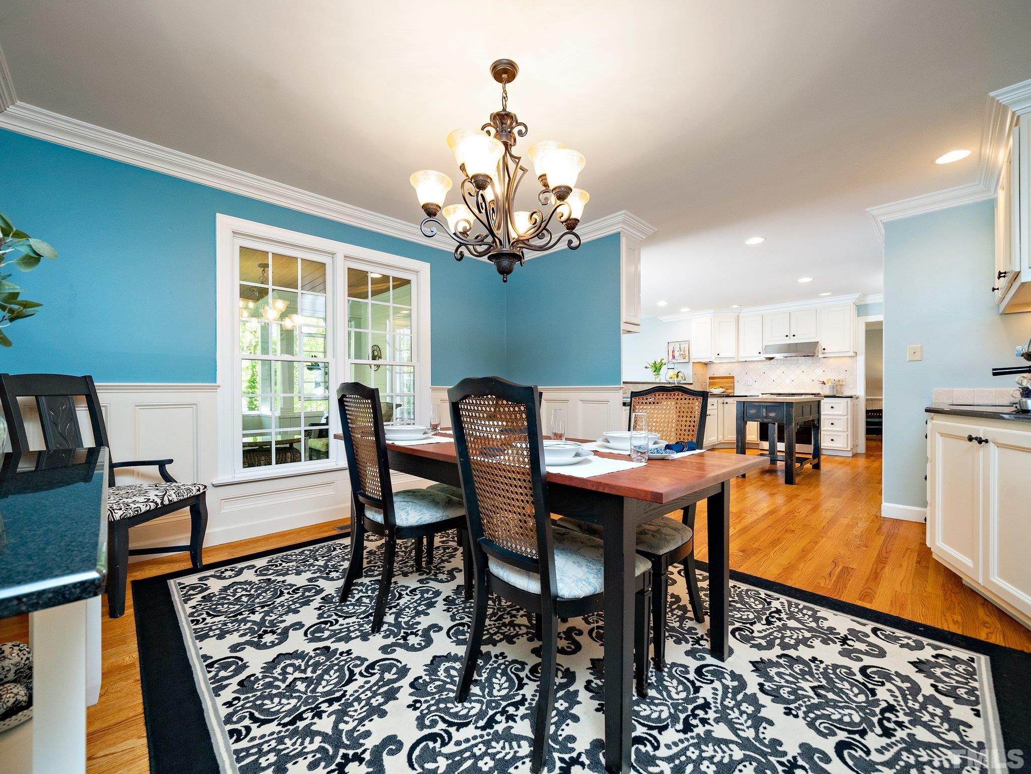 4508 Old Village Road Raleigh, NC 27612 - Photo 7 of 29 a dining room with furniture a rug and a chandelier