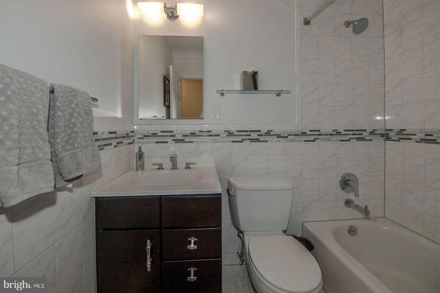 7906 Inverness Ridge Road Potomac, MD 20854 - Photo 21 of 30 a bathroom with a granite countertop sink a toilet and bathtub