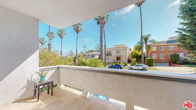 a kitchen with stainless steel appliances granite countertop a sink a stove and a refrigerator with wooden floor