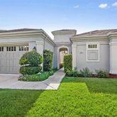 a front view of a house with a garden and plants