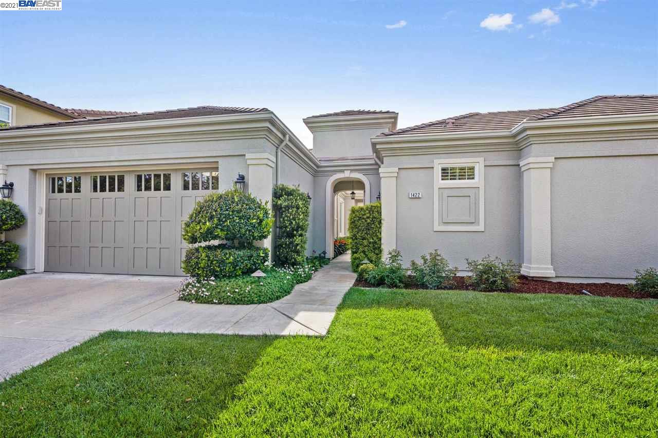 a front view of a house with a garden and plants