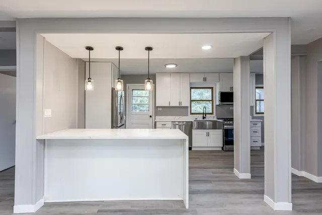 a large kitchen with a large counter top appliances and cabinets