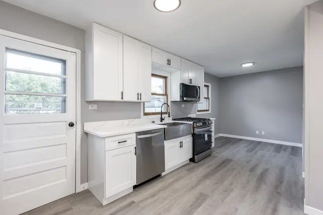 a large kitchen with a stove top oven sink and cabinets