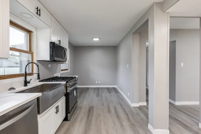 a kitchen with a sink stove top oven and refrigerator