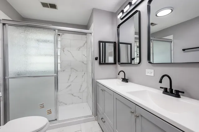 a bathroom with a sink a toilet and shower