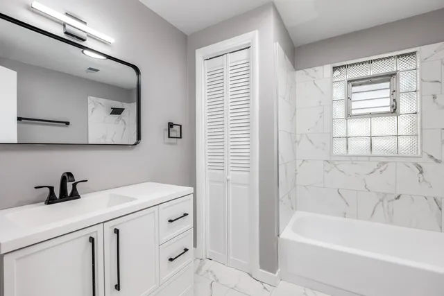 a bathroom with a bathtub a sink and a window