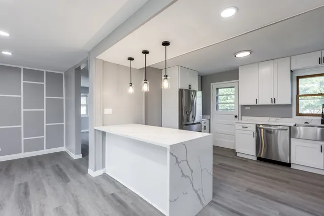 a large kitchen with a lot of counter space and wooden floor