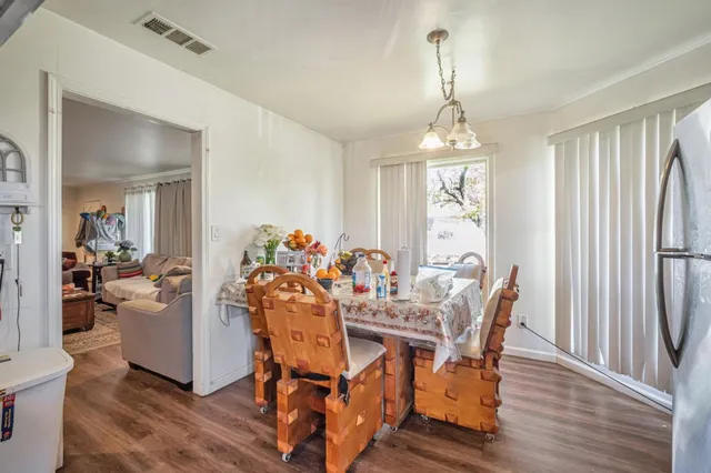 a dining room with furniture a chandelier and wooden floor