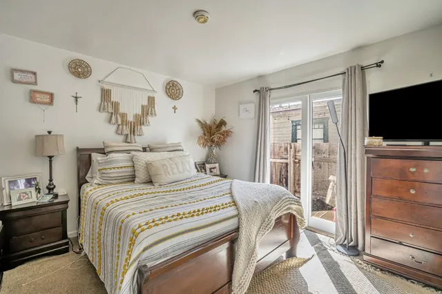 a bedroom with a bed and a flat tv screen on the dresser