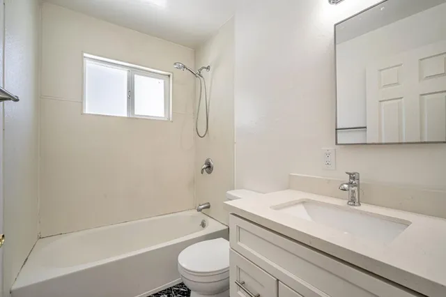 a bathroom with a granite countertop toilet a sink and a bathtub