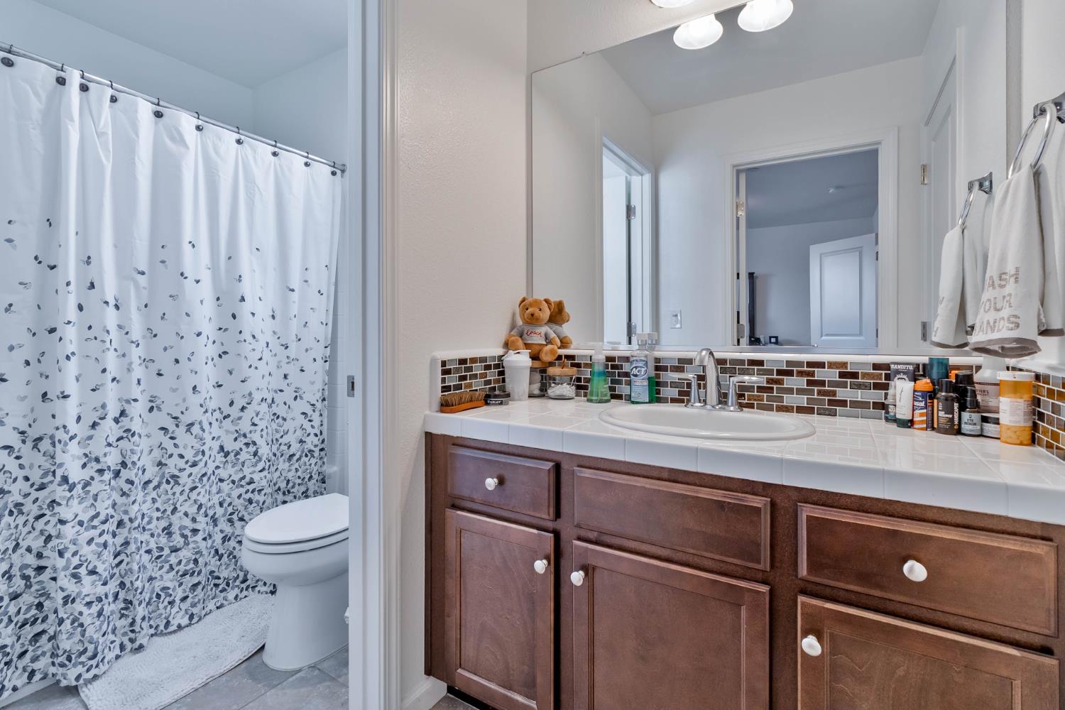 915 Winchell Way West Madera, CA 93636 - Photo 12 of 36 a bathroom with a sink a toilet and a mirror