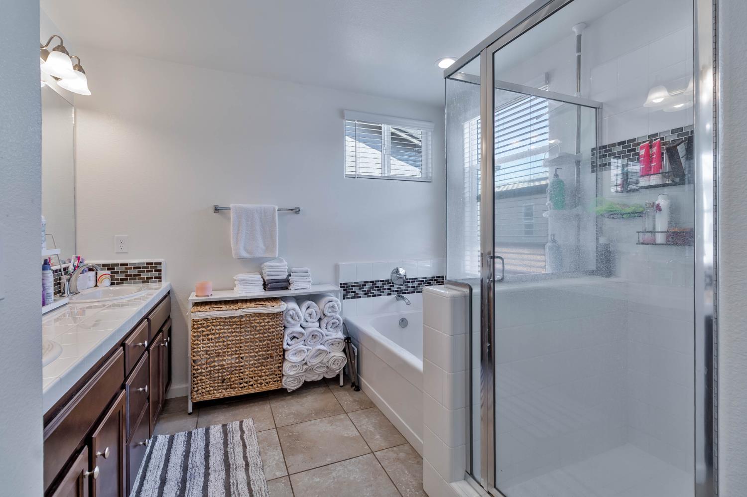 915 Winchell Way West Madera, CA 93636 - Photo 21 of 36 a bathroom with a tub sink vanity granite and a shower