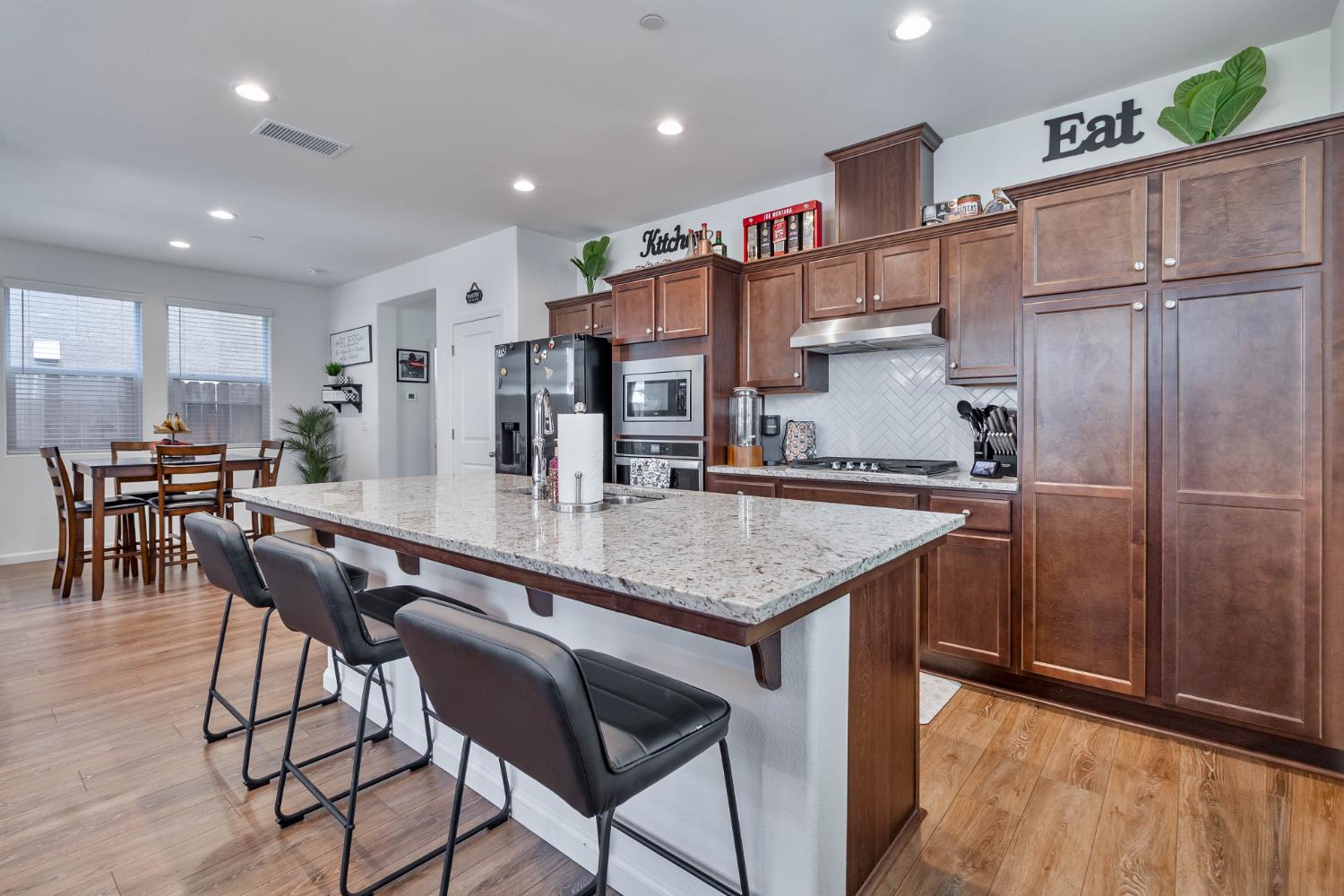 915 Winchell Way West Madera, CA 93636 - Photo 23 of 36 a kitchen with stainless steel appliances granite countertop a table chairs and a refrigerator