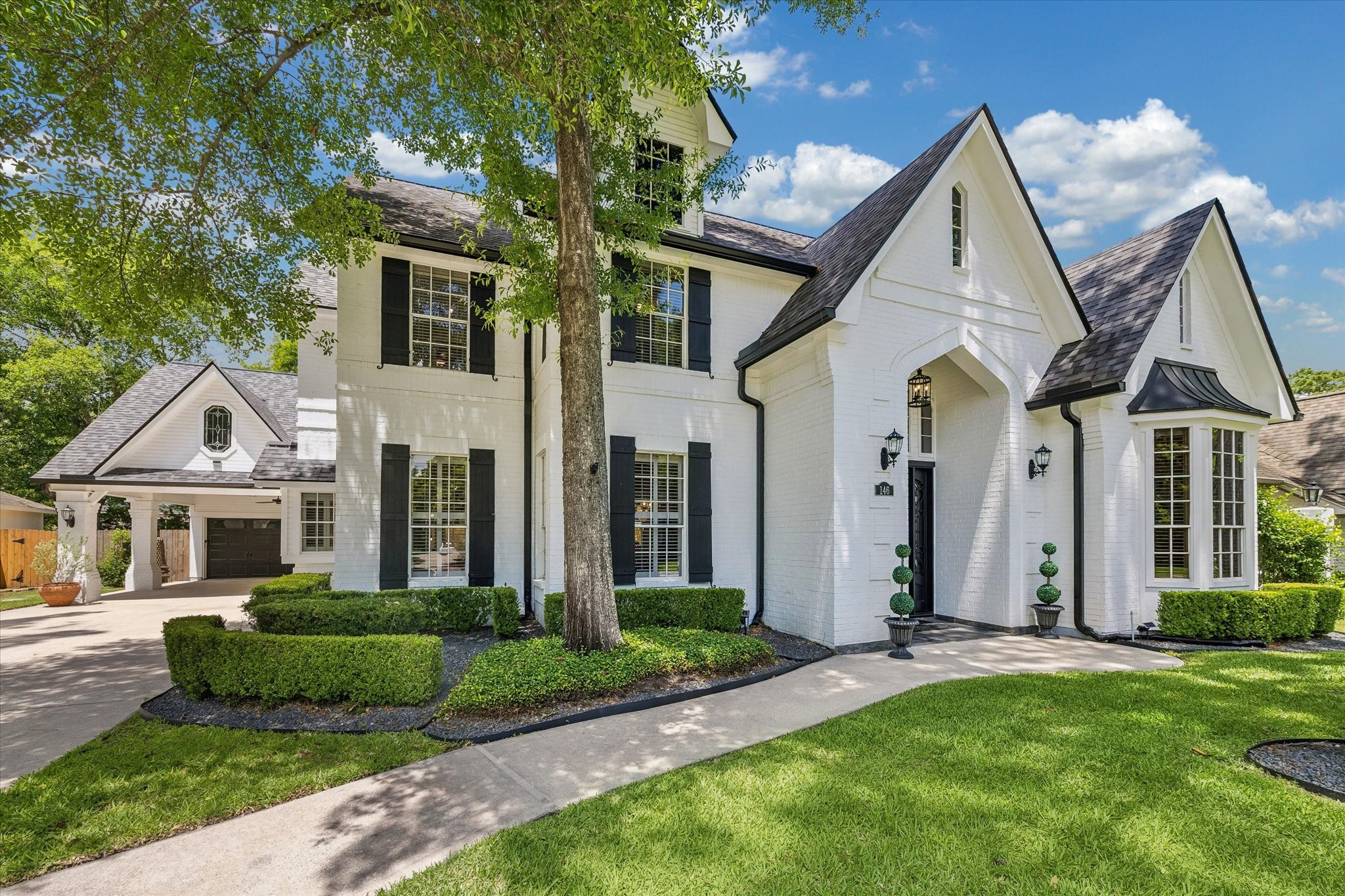 146 Golden Shadow Circle Spring, TX 77381 - Photo 2 of 41 Framed by thoughtful architectural details, the covered front porch features a slate floor and a custom steel-and-glass front door system (2024), creating a warm and elegant welcome.