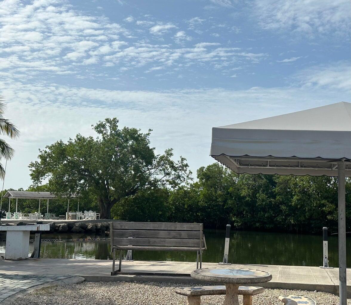338 Sound Drive Key Largo, FL 33037 - Photo 3 of 6 a view of a lake with a bench and trees around