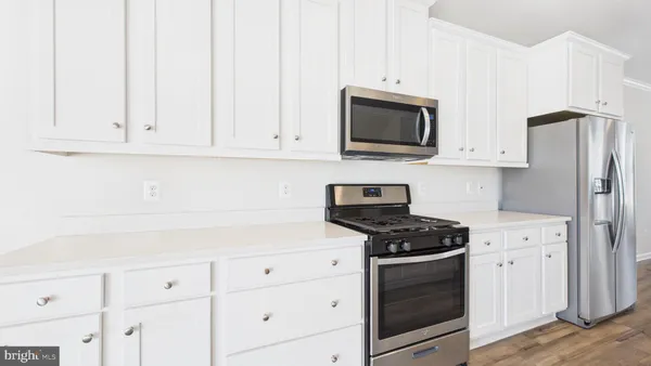 a kitchen with white cabinets and stainless steel appliances