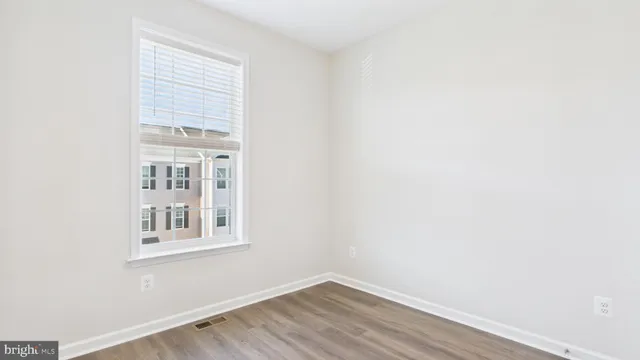 a view of a small space with wooden floor and a window