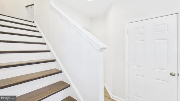 a view of staircase with white walls and a window