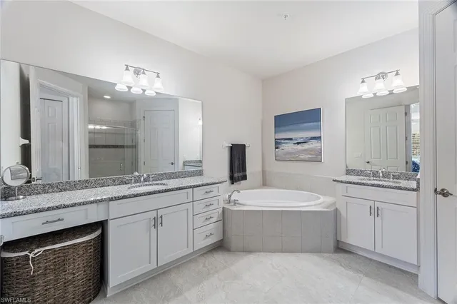 a bathroom with a sink a large mirror and a bathtub