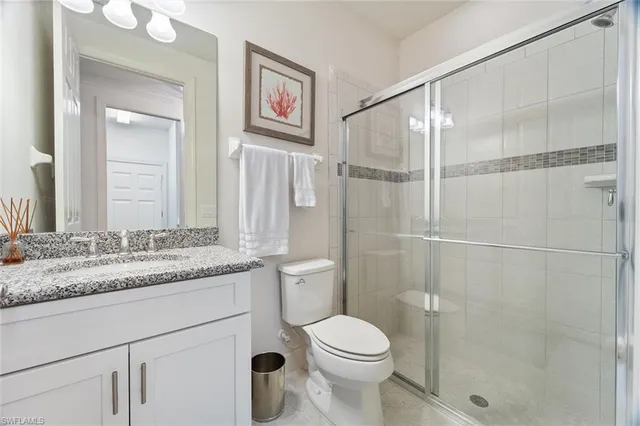 a bathroom with a granite countertop sink toilet and shower