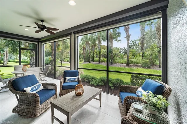 a living room with patio furniture and a garden